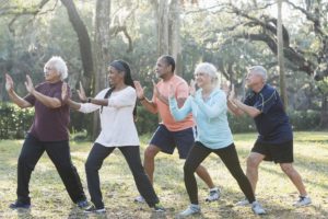 Diverse group doing tai chi outdoors.